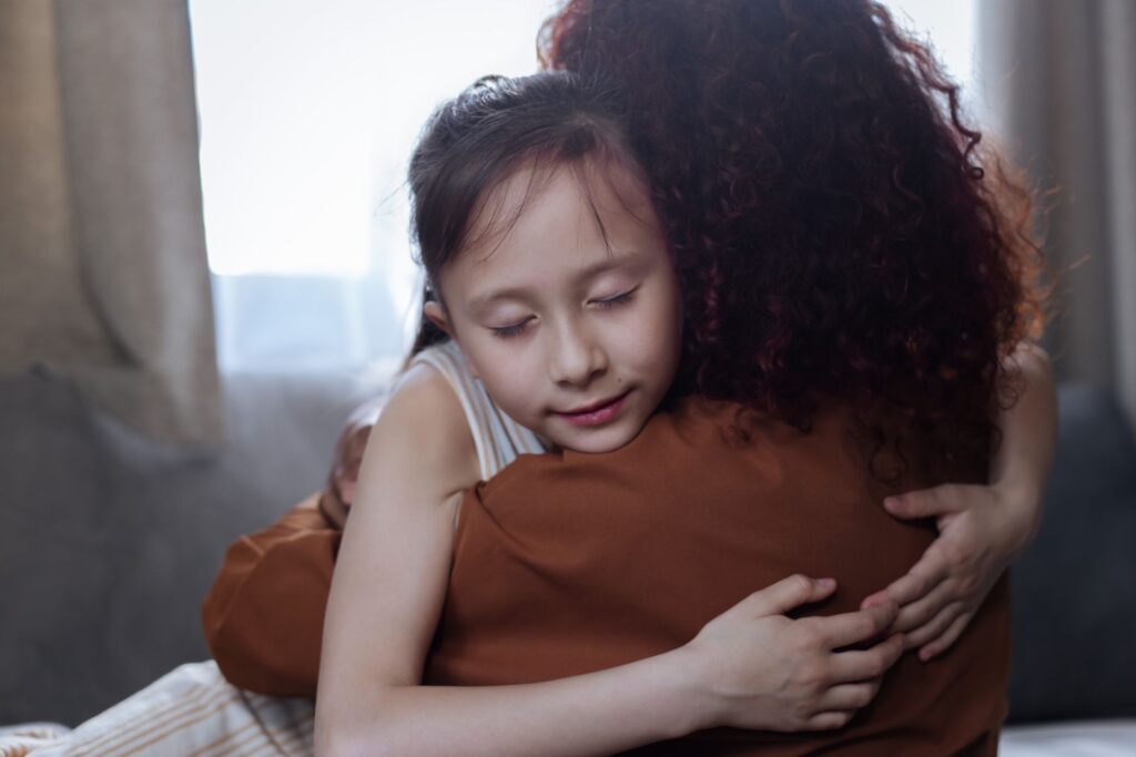 Criança abraçada à mãe buscando conforto — ansiedade no autismo
